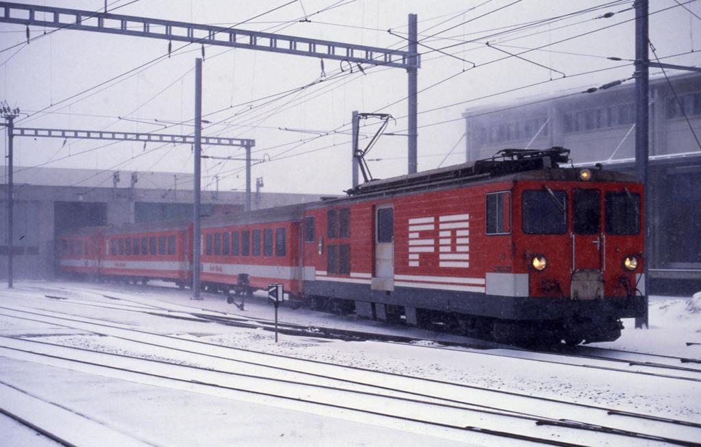 Schneefall im Mrz verschleiert das Bild am 6.3.1990 im Bahnhof Andermatt,
als FO Lok 92 einen Personenzug aus dem Depot zieht.