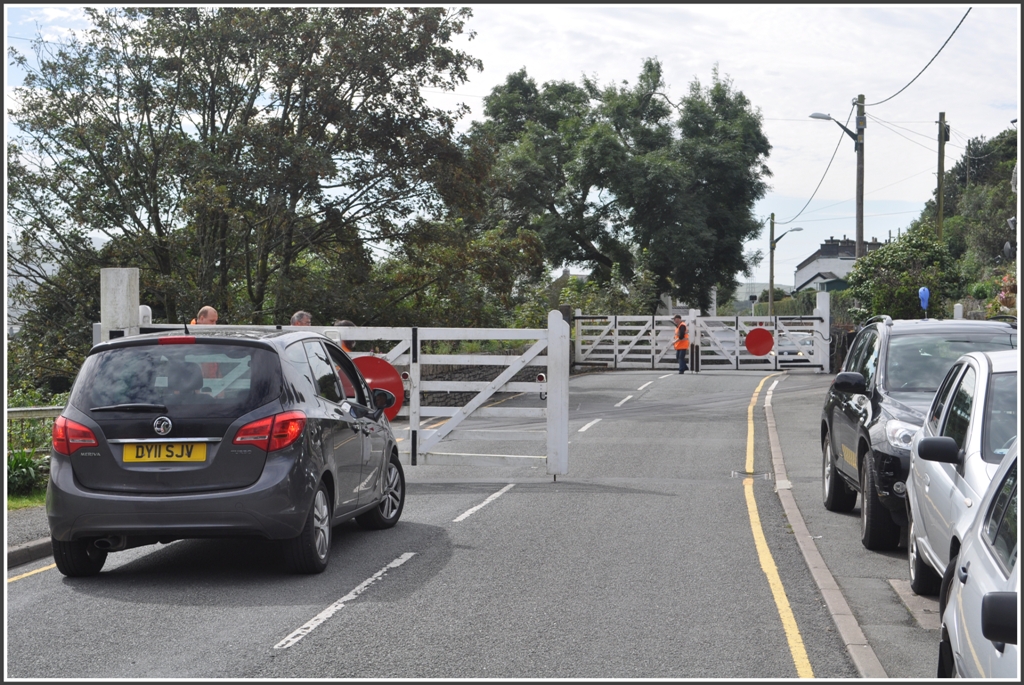 Schrankenbergang ber die A4085 in Penrhyn an der Ffestiniog Railway, wo wechselseitig die Bahn oder die Strasse gesperrt werden. Dabei ist viel Handarbeit ntig. (04.09.2012)