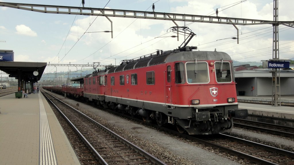 Schwere Last haben am 02.05.11 die Re 6/6 11621  Taverne-Torricella  und die Re 4/4  11318 zu schleppen. In Rotkreuz legen sie mit ihrem Gleistransport-Zug einen kurzen Halt (inkl. Panto-Senkung) ein.