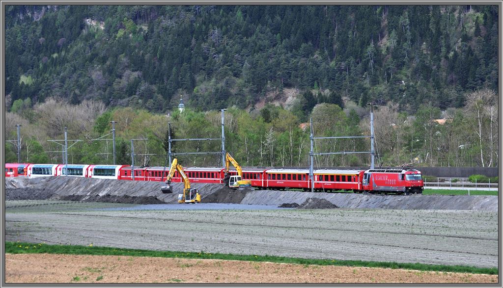 Seit rund einer Woche bedroht eine riesige Rfe (Murgang) aus dem Pargheratobel den Talgrund bei der Station Felsberg. Whrenddem die Kantonsstrasse Chur-Domat/Ems seither berflutet und unpassierbar ist, wird jetzt mit Hochdruck versucht die Bahnlinie der RhB sowie die Autobahn N13 vor den stndig fliessenden Schlamm- und Gerllmassen zu schtzen. Entlang der doppelspurigen Bahnlinie wird momentan ein tiefer Graben ausgehoben und ein Damm aufgeschttet. Noch rollt der Zugsverkehr normal, wie hier RE1128/GEX903 mit Ge 4/4 III 651  Fideris . Rfe Pargheratobel. (27.04.2013)