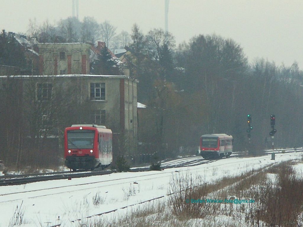 Seltene Begegnung in Oberkotzau am 27.01.2010. Ein 628 fhrt hinten rechts in den Bahnhof ein, whrend links 650016 auf dem Weg ins Ausbesserungswerk ist. Auf einem Nachschuss in der Kurve konnte man erkennen, dass auf der hier abgewandten Fahrzeugseite eine Tre mit Folie verklebt ist. Ggf. hatte der Tw also eine kleine Feindberhrung..