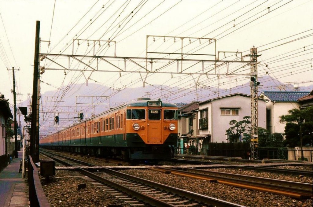 Serie 111 auf der Sanyô-Magistrale: Die Sanyô-Magistrale führt vom Ballungszentrum Osaka dem Pazifik entlang bis ans westliche Ende der japanischen Hauptinsel in Shimonoseki. Im Bild einer der ältesten Züge Serie 111 (mit schwächeren Motorwagenpaaren Serie 111/110). Suma, 14.Februar 1977. 
