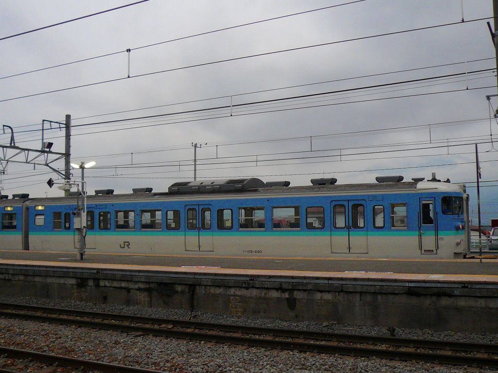 Serie 115 des zentraljapanischen Hochlands: Steuerwagen KUHA 115-440 steht in Kobuchizawa, während dahinter die Alpen in dichten Nebel gehüllt sind. 24.November 2009. 
