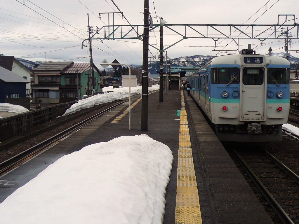 Serie 115 des zentraljapanischen Hochlands: An der Pass-Strecke, die das Japanische Meer mit dem Nagano-Becken verbindet, steht ein Zug im Bahnhof Arai. Die Züge mit diesem Anstrich mit hellblauer Fensterpartie sind der Region Nagano zugeteilt. Im Bild Steuerwagen KUHA 115-1227, 2.März 2010. 