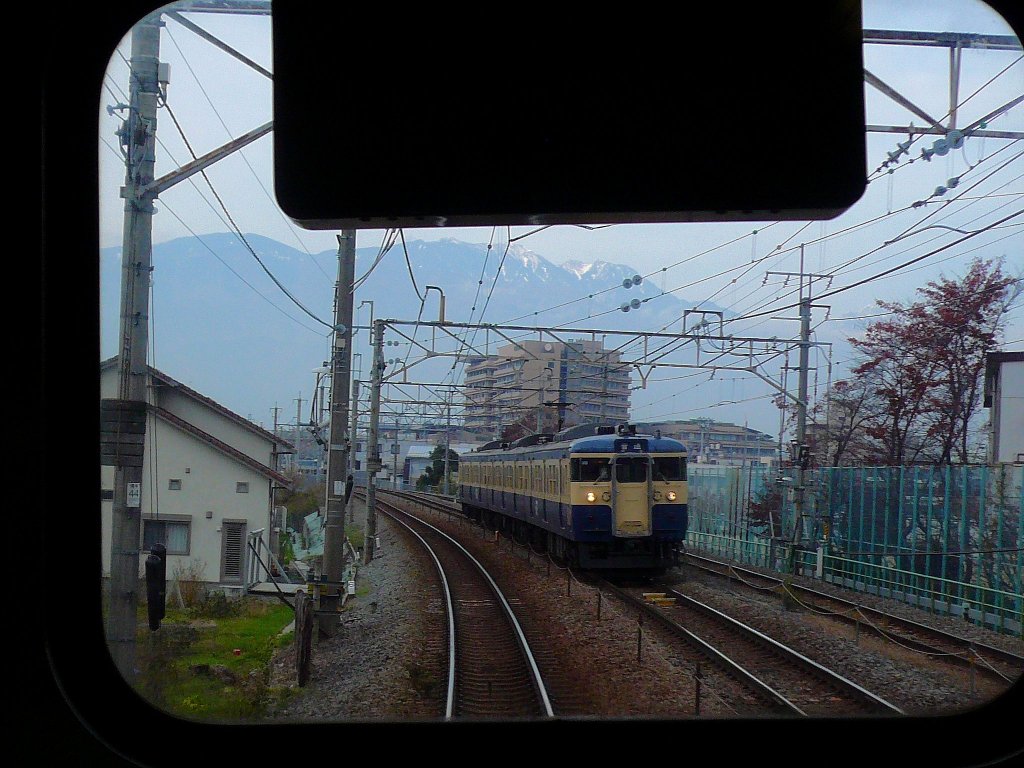 Serie 115 des zentraljapanischen Hochlands: In Ryûô am Fusse der Alpen begegnet ein Dreiwagenzug, geführt von KUMOHA 115-311. Er besteht aus einem Motorwagenpaar Serie 115+114 (115 mit Führerstand) und einem Steuerwagen Serie 115. 24.November 2009. 