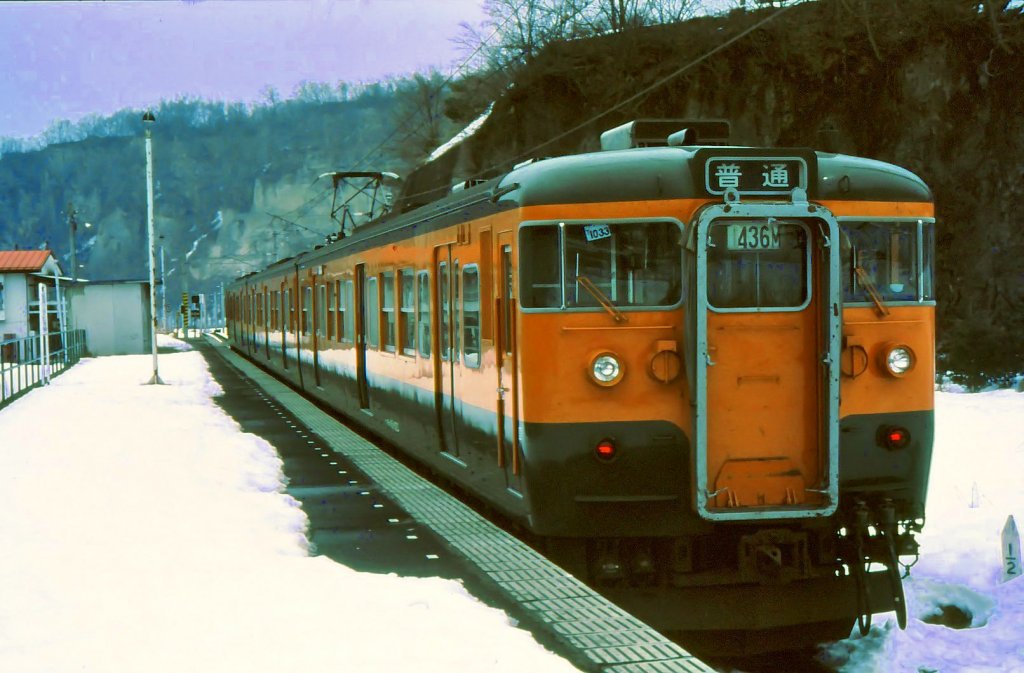 Serie 115 des zentraljapanischen Hochlands: Dreiwagenzug mit motorisiertem Endwagen KUMOHA 115-1023 in Ômae am Ende der Agatsuma-Linie im zentralen Gebirge. 8.März 1985.