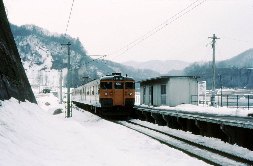 Serie 115 des zentraljapanischen Hochlands: Tief im Gebirgstal der Agatsuma-Linie steht ein Dreiwagenzug mit Steuerwagen KUHA 115-1023 an der Endstation Ômae, 8.März 1985.