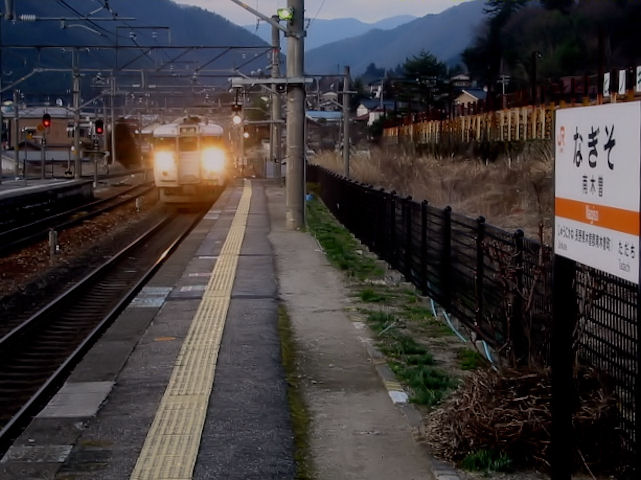 Serie 115: In der Abenddämmerung fährt ein Triebzug der Strecke durchs steile Kiso-Tal (Frontwagen KUMOHA 115-1036) in Nagiso ein, 4.März 2007.