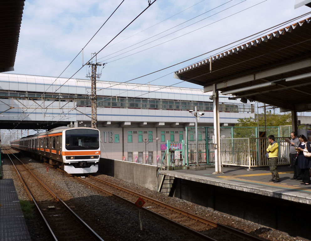 Serie 209-500: Einfahrt eines Zuges der Musashino-Linie (äussere Ringlinie um Tokyo) in Minami Koshigaya; Frontwagen KUHA 209-514. Ein typischer Umsteigebahnhof: Oben drüber fährt die Tôbu-Privatbahn, die Station ist zugleich ein Warenhaus mit vielen Dienstleistungsbetrieben. 8.Oktober 2011. MUSASHINO-LINIE 