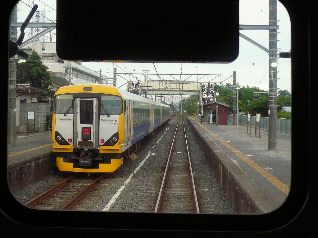 Serie 257: Kreuzung mit einem Zug der Serie 257-500 in der Nähe des Fischerhafens Chôshi, östlich von Tokyo. Steuerwagen KUHA 256-509, Higata, 1.Juli 2010. Aufnahme aus dem rückwärtigen Fenster eines Gegenzugs. 