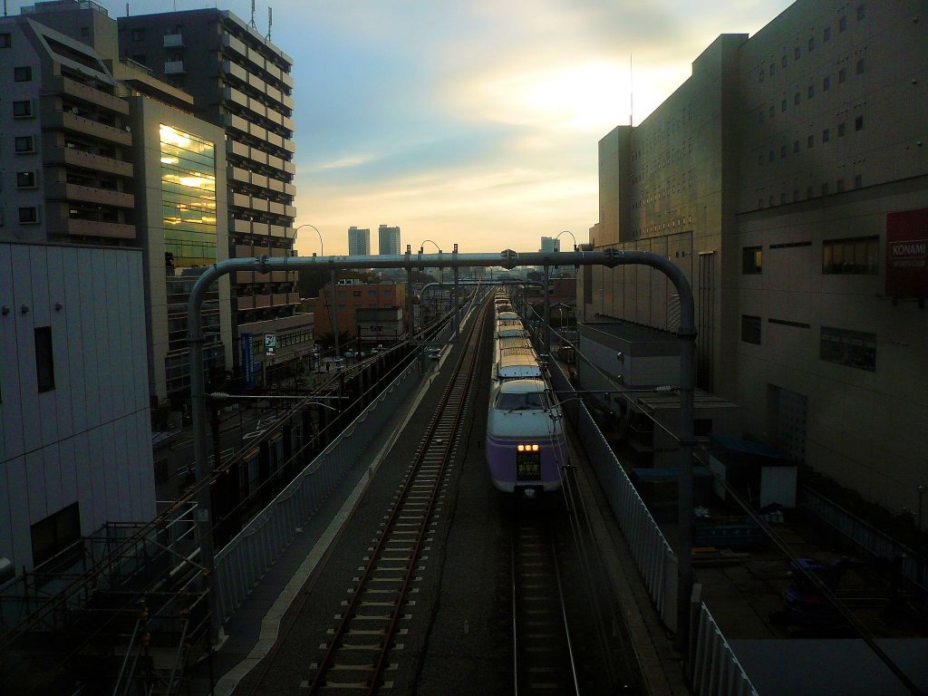 Serie 351: Im ersten Morgenlicht tastet sich ein Zug aus dem Häusermeer von Tokyo hinaus in Richtung Matsumoto im den zentraljapanischen Bergen. Tokyo-Musashi Sakai, 24.November 2009. 