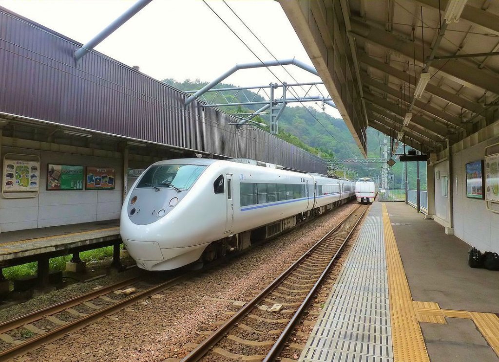 Serie 681 (JR): 1992/95-97 gebaute Züge für 1500 V Gleichstrom und 20kV/60 Hz Wechselstrom. Einsatz von Osaka aus zu den grösseren Städten Fukui, Kanazawa und Toyama am Japanischen Meer, und von dort über die Strecke des Hokuetsu Express (hier V max 160km/h!) nach Echigo Yuzawa, wo Shinkansen-Anschluss nach Tokyo besteht. Es gibt 84 Wagen (+ 18 Wagen im Eigentum des Hokuetsu Express), heute aufgeteilt in 10 3-Wageneinheiten und 9 6-Wageneinheiten. Die Züge haben ein  Kopf-Ende  (im Bild der einfahrende 3+6-Wagenzug links) und ein Ende mit Hochführerstand und Durchgangstüre (im Bild die davonfahrende 6-Wageneinheit rechts). Aufnahme in Mushigawa Ôsugi auf der Strecke des Hokuetsu Express, 16.Oktober 2011. Der Zug links wird geführt vom Steuerwagen KUHA 681-6. 