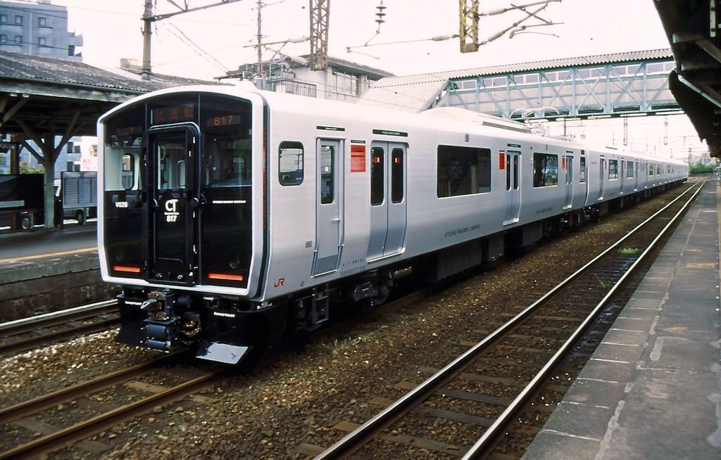 Serie 817: Drei ganz neue Züge - vorn Zug Nr. 26 - kommen gerade von der Fabrik und stehen im Bahnhof Kurume, 15.September 2001. 