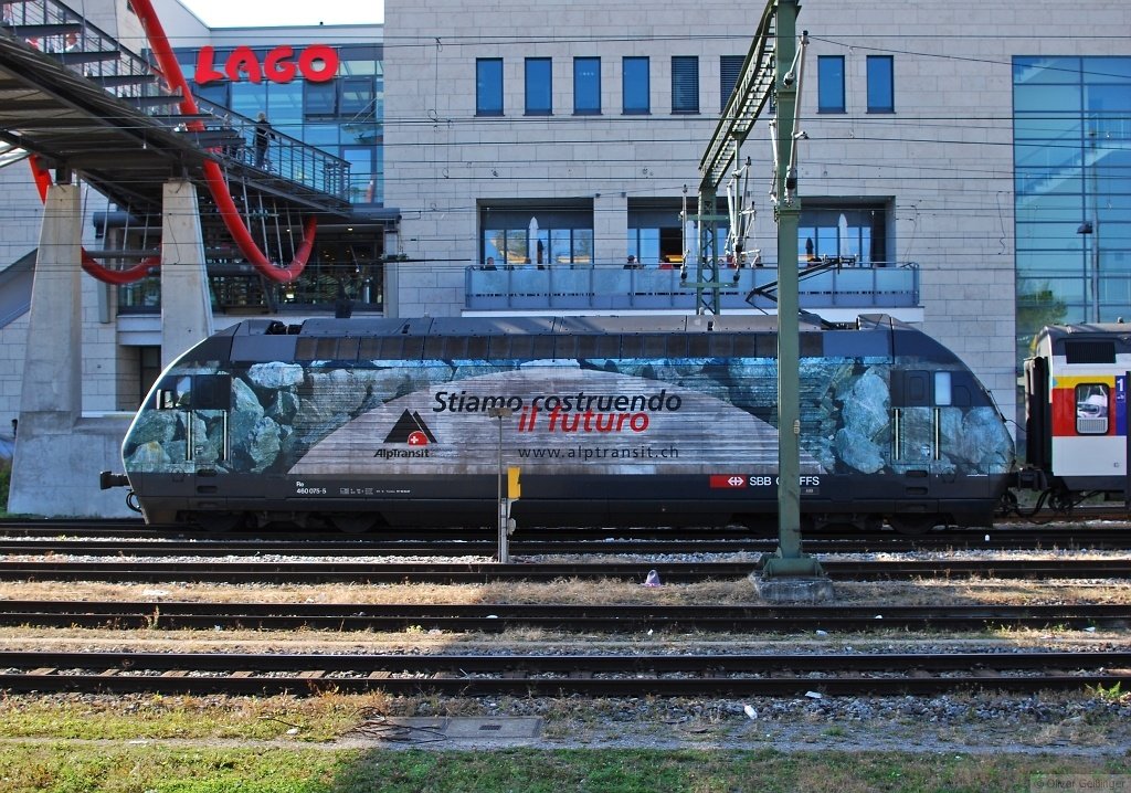 Siamo costruendo il futuro (I). Die Werbung auf 460 075-5 ist Programm auch am Endpunkt der Linie Biel-Konstanz. Hier vor dem bereits existenten aber futuristischen Lago Center. Anlsslich der Einweihung des neuen Eisenstegs ber den Bahnhof Konstanz eine kurze Serie ber die „Konstruktionsttigkeiten“ am Bahnhof Konstanz. (03. Oktober 2009)