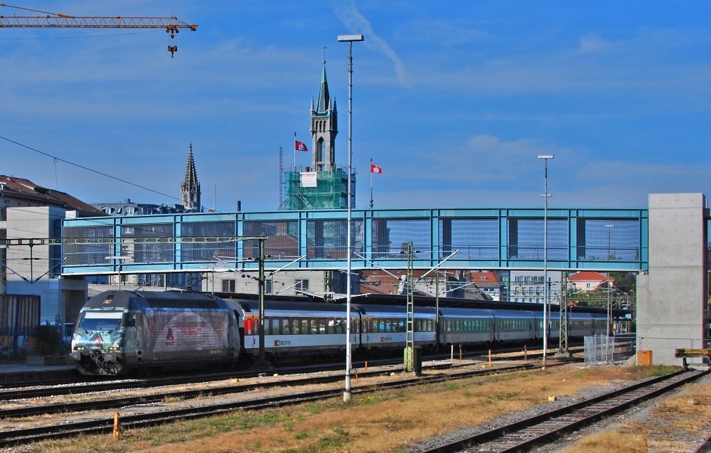 Siamo costruendo il futuro (II). 460 075-5 startet Richtung Biel via Z�rich. Diese Schnellzugverbindung wurde erst vor ca. 10 Jahren eingerichtet, hatte aber schnell au�ergew�hnlich gro�en Erfolg. Da waren die zwischenzeitlich eingesetzten ICN sogar zu klein. Dar�ber der neue Eisensteg �ber den Bahnhof, noch nicht fertiggebaut, und ebensowenig fertig der noch teilweise einger�stete Bahnhofsturm. Im Bahnhof und auf den Bahnsteigen ist trotz einer �berzeugenden Sanierung im Jahr 1983 mittlerweile weiterer Sanierungsbedarf. (03. Oktober 2009)