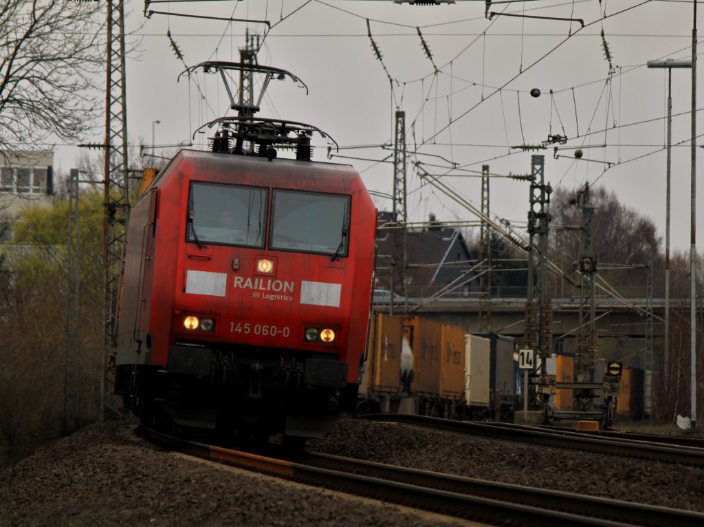 Sich elegant in die Kurve legend zieht 145 060-0 am 26.03.2011 auf der KBS 480 bei Aachen Rothe Erde einen langen Containerzug nach Aachen West.