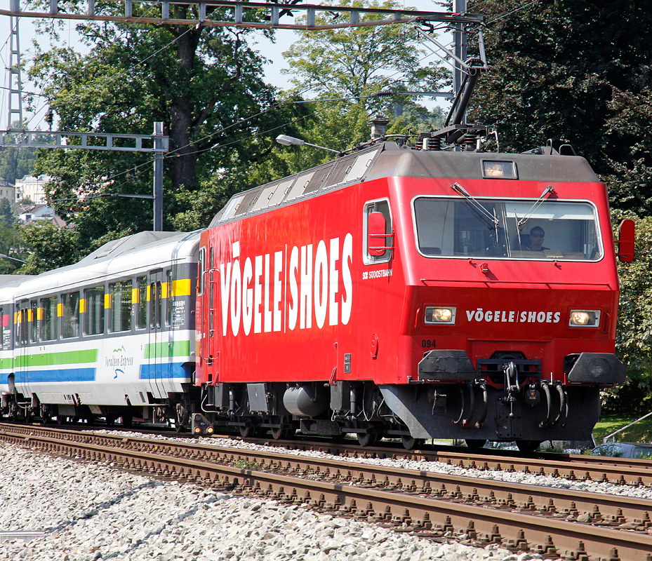 SOB-Re 456 094 im Werbelook  Vgele Shoes  zieht den Voralpen-Express in Richtung Arth-Goldau und erreicht in Krze die Haltestelle Verkehrshaus. Aufnahme vom 22. Aug. 2012, 13:48