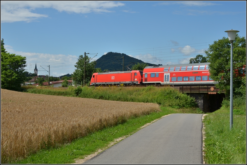 Sommertag im Hegau. Hier kommt eine 146 mit IRE der Schwarzwaldbahn in die Bodenseeregion. Im Hintergrund der hchste Hegauvulkan Hohenhewen, der Kirchturm linkerhand markiert den mittelalterlichen Ortskern von Engen. Juli 2012.