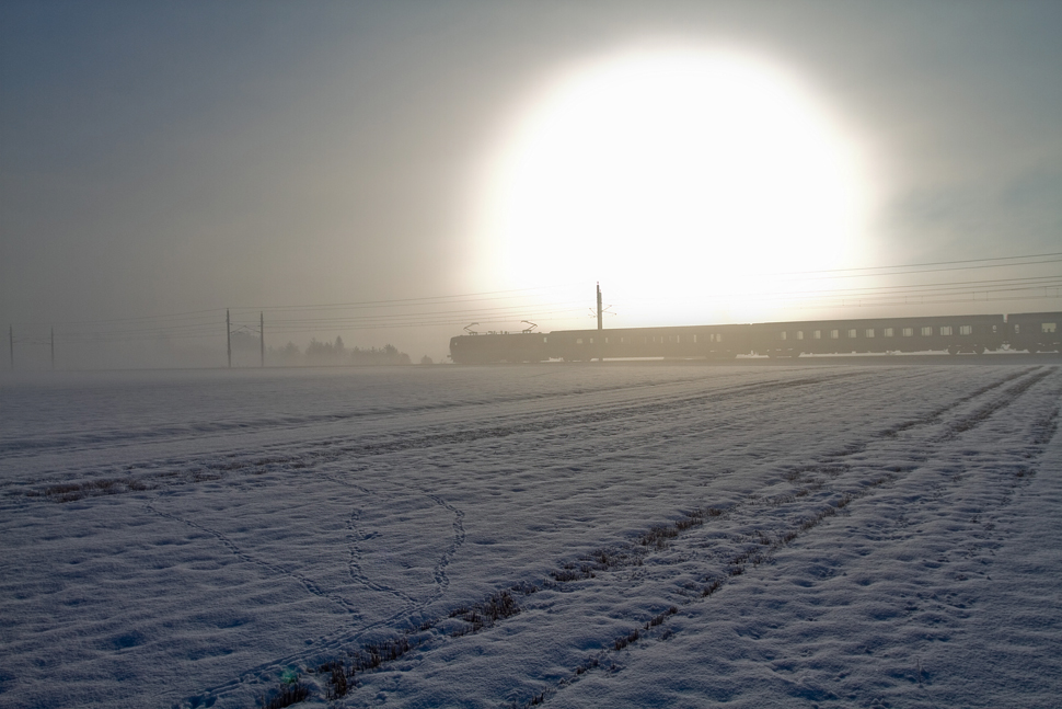 Sonnenaufgang im Aichfeld. Eine Lok der BR 1044 fhrt mit IC 534 von Villach nach Wien Meidling. 
Zeltweg 23.1.2011 
