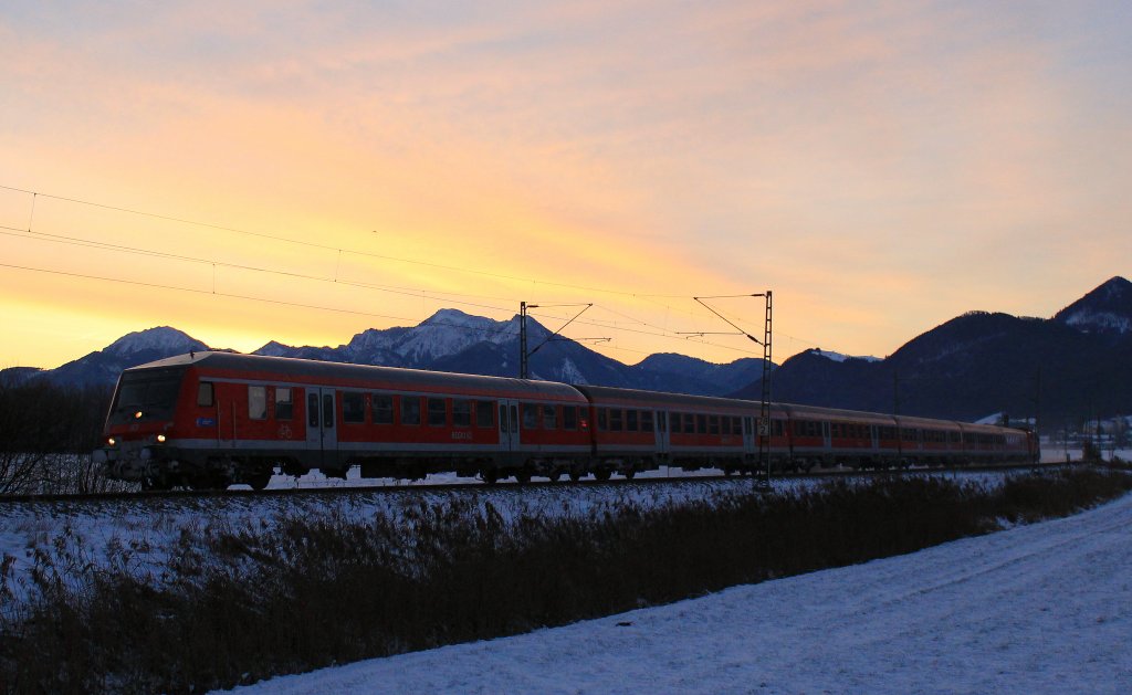 Sonnenaufgang am 7. Dezember 2012 mit einem Regionalzug zwischen Bernau und Prien am Chiemsee. Der Regionalzug ist auf dem Weg von Salzburg nach Mnchen.