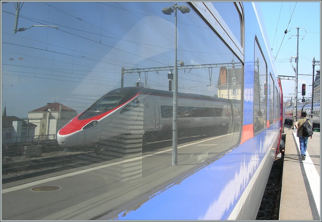  Spiegelreflex extern : in der Scheibe eines TGV nach Paris spiegelt sich der ausfahrende Pinocchio der als EC 32  von Milano nach Genve unterwegs ist. 
Lausanne, den 23. Mrz 2012