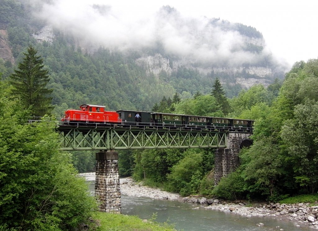 Springt er oder springt er nicht? Selbstverstndlich ist der Mann nicht aus dem Gepckwagen gesprungen. Am 03.06.2012 fhrt der erste Zug der Bregenzerwaldbahn von Schwarzenberg nach Bezau ber die Sporeneggbrcke. Diese Brcke strzte 1999 in Folge des Hochwassers der Bregenzerach ein. Im Jahr 2000 wurde die Sporeneggbrcke wiedererffnet.