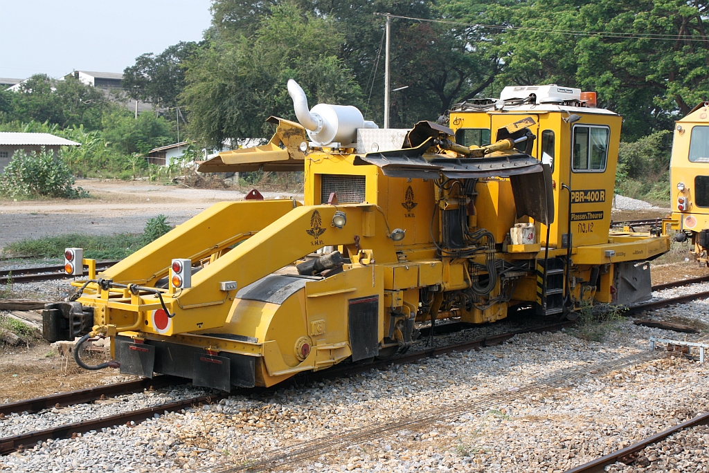 SRT กน.12 (กน.=BR./Ballast Regulator) eine Schotterkehr- und Planiermaschine der Type PBR-400R am 13.März 2011 im Bf. Nong Pladuk Junction.