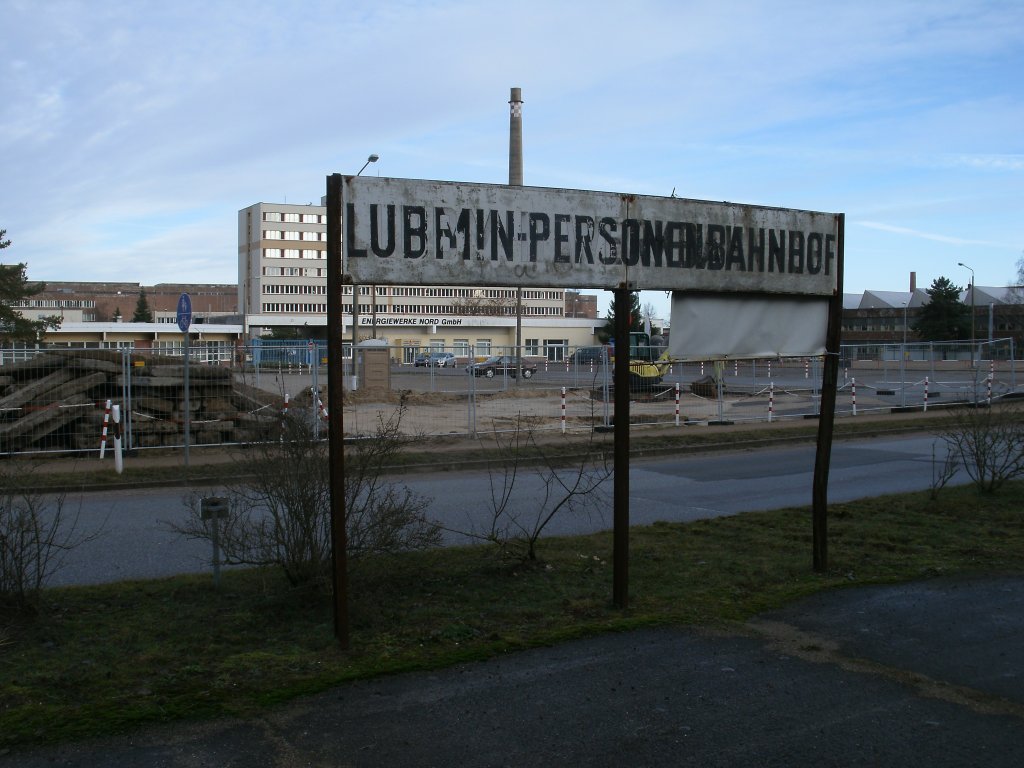 Stationschild  Lubmin Personenbahnhof  am 05.Januar 2013.Im Hintergrund das frhre Kernkraftwerk.