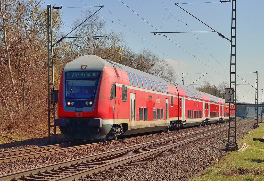 Steuerwagen voraus kommt am Sonntag den 7.4.2013 ein RE7 Zug nahe Osterath in Richtung Krefeld Hbf am Fotografen vorbei. Der Zug wird von der 112 137 geschoben.