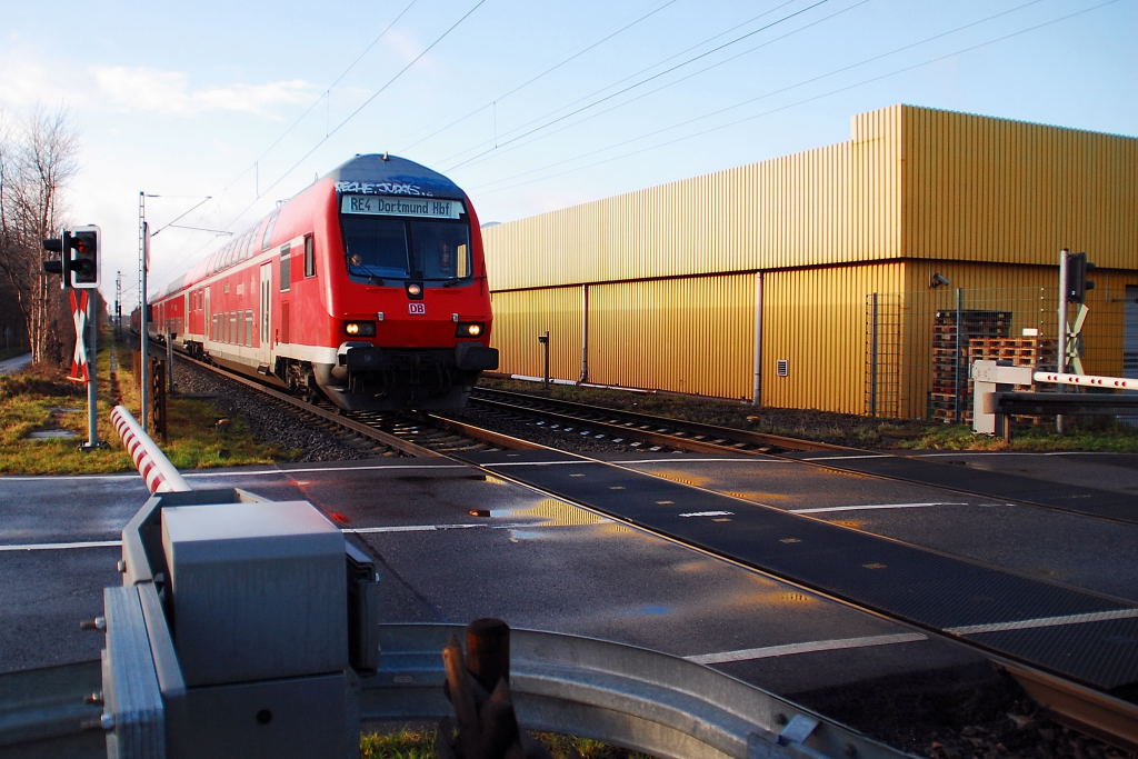 Steuerwagen voraus kommt dieser RE4-Zug geschoben von 111 124-4 an den Bahnbergang Herrather Linde am 24.12.2011