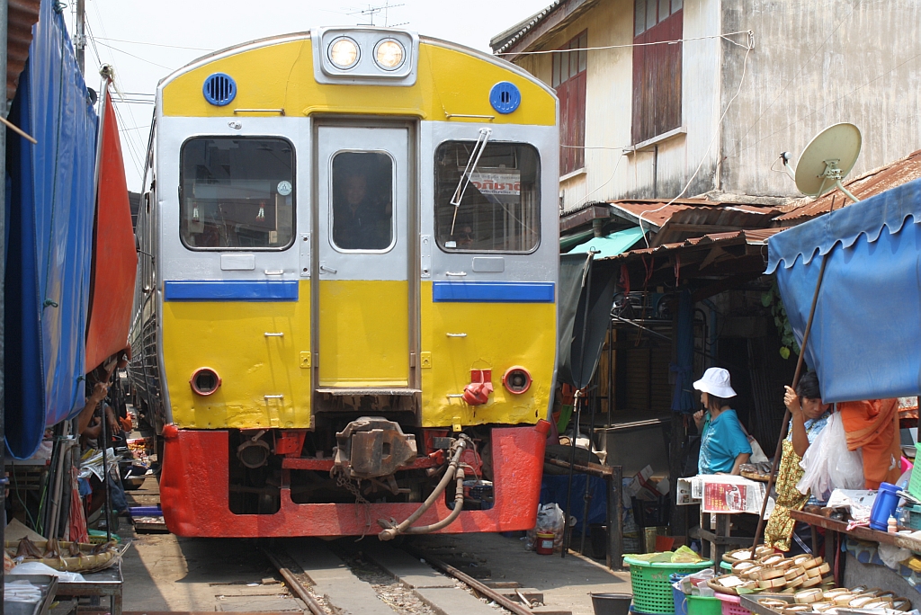 Strecken-KM 33,600, gleich beim Bf. Mae Klong am 27.März 2010. Der nummernlose Triebwagen auf der Fahrt über die nun frei gegebene Strecke, welche als Markt genutzt wird.