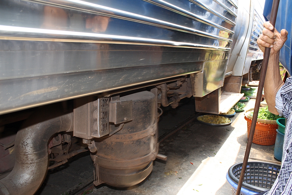 Strecken-KM 33,600, gleich beim Bf. Mae Klong am 27.März 2010. Die Marktverkäufer haben das Lichtraumprofil wahrlich gut ausgelotet.