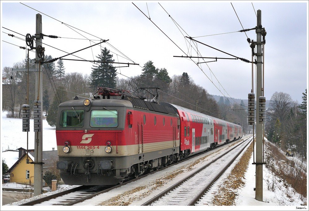 Sumsi am Bahndamm: 1144.265 mit REX 1614 bei der Einfahrt in die Hst. Pressbaum, 17.1.2010.