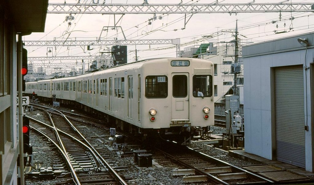 Tôbu-Konzern Serie 2000 / Tokyo Metro Hibiya-Linie: Die Serie 2000 sind die Vorgänger der Serie 2xxxx; 1961-1971 gebaut (160 Wagen) für den durchgehenden Verkehr von den Strecken des Tôbu-Konzerns über die Hibiya-Linie der heutigen Tokyo Metro U-Bahn. 1993 ausgeschieden. Aufnahme von Zug 2102 praktisch am selben Ort (vom anderen Bahnsteig aus) wie das Bild von Zug 21813 20 Jahre später; Naka Meguro, 2.Juli 1979. 