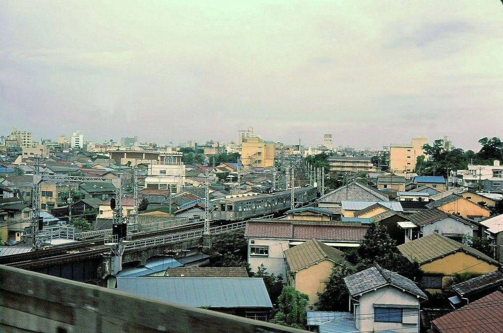Tôkyû-Konzern, Serie 7000: Typisches Tokyo am Ende der 1970er Jahre. Eine Komposition mit 7055 an der Spitze im Häusermeer von Tokyo-Ôimachi. Aufnahme aus einem Shinkansen-Zug, 3.Juli 1979. 