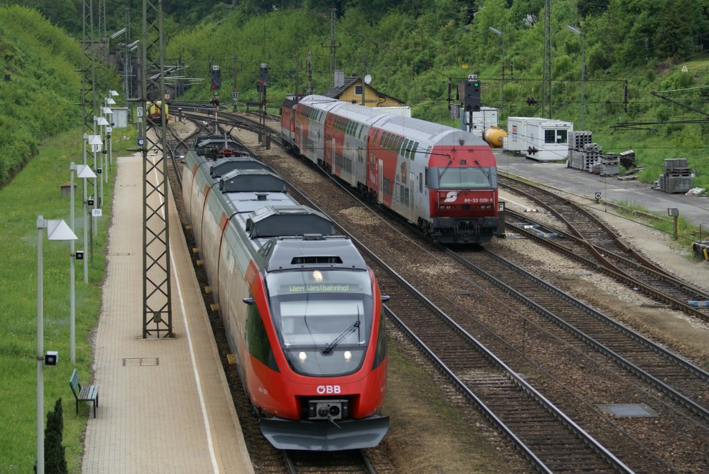Talent 4024 132  Leopoldstadt  fahrt als R2023 von St.P�lten nach Wien West gerade in die n�chste Haltestelle Rekawinkel ein. Richtung St.P�lten donnert gerade die 1144 222 mit dem REX1618  Oskar Kokoschka  St.Valentin entgegen. 15.5.2010