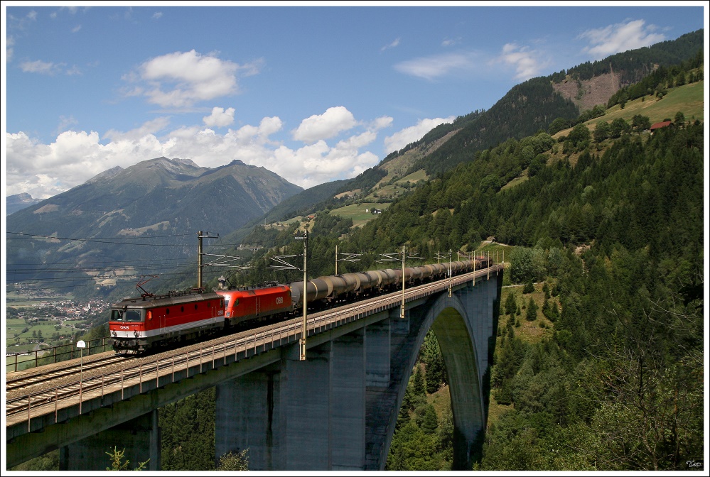 Talwrts ber die Tauern-Sdrampe rollt dieser Kesselwagenzug,bespannt mit der 1144 257 und einer 1116. 
Pfaffenberg-Zwenbergbrcke nahe Penk 2.8.2010