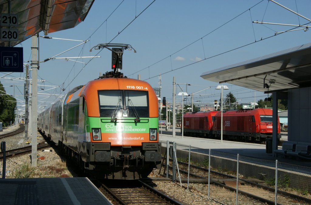Taurus-Werbelok 1116 007  SOS Kinderdorf  schiebt den DoSto-Cityshuttle REX7128 aus dem Bahnhof Wien Meidling in Richtung Floridsdorf. Im Hintergrund wartet die 2016 014 und eine weitere 2016 auf die Freigabe abfahren zu drfen.