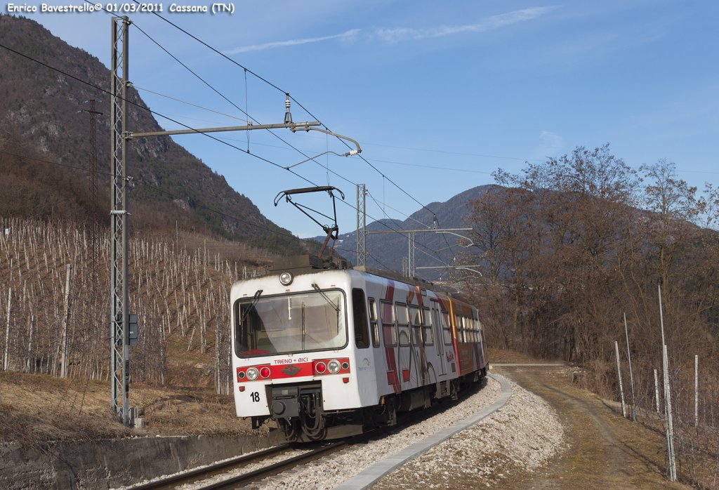 The ET 18 with  Treno + Bici  special livery transit near of Cassana with the local train n. 27 from Marilleva to Trento. (March 1, 2011)