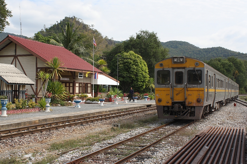 THN 1132 wartet als ORD 407 am 08.Jnner 2011 im Bf. Kaeng Luang auf die Kreuzung mit dem RAP 102. Man beachte, da man den Reisenden das Aus- und Zusteigen auch ohne Bahnsteig und sogar ber die Drhte der Signalanlage zumutet. Dies wre im geordnetem Westen eigentlich nicht ffentliches Gelnde. 

