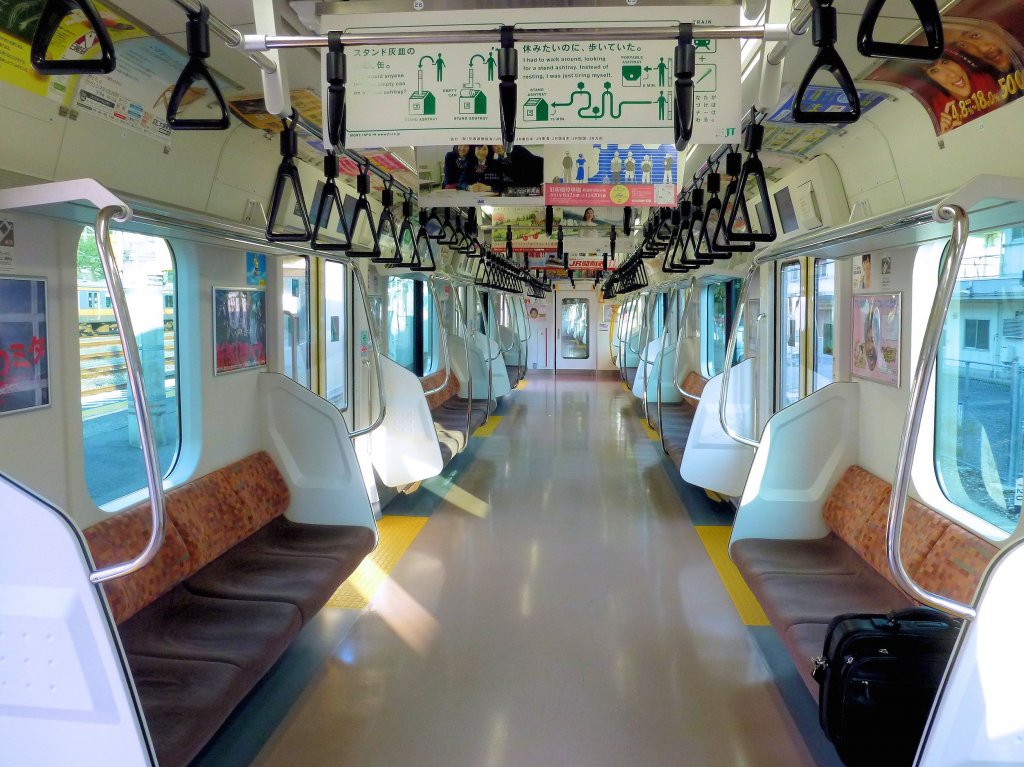 Tokyo S-Bahn, Serie 233: Das saubere und zweckmässige Innere des Steuerwagens KUHA 232-41, der eine sehr hohe Fahrgastdichte zu bewältigen hat. 23.Oktober 2011.  