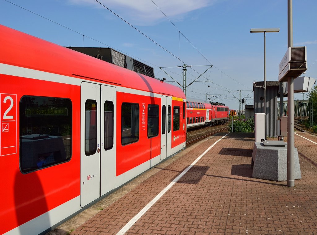 Triebkopf 423 763 steht am Bahnsteig in Neuss Am Kaiser, als eine unbekannte 111 mit einem RE4 Zug nach Dortmund in Richtung Rheinbrcke vorbeifhrt. 27.7.2013