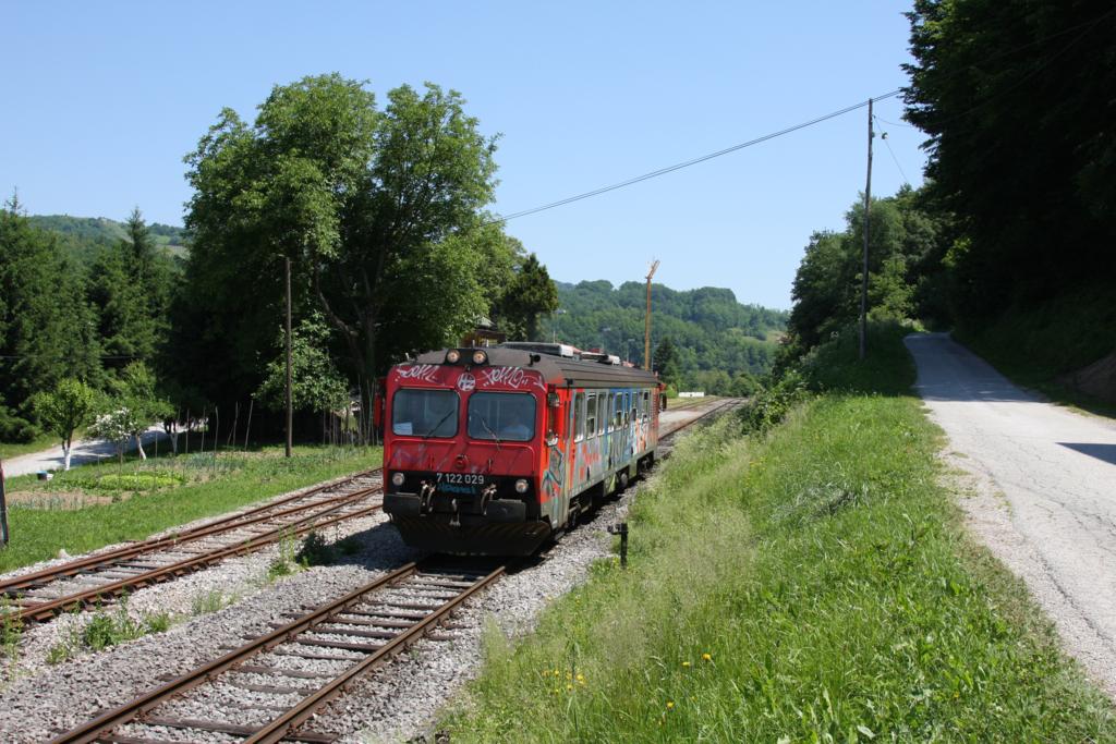 Triebwagen 7122029 der HZ hat gerade den kleinen Bahnhof Kamanji 
verlassen und fahrt am 27.5.2011 weiter in Richtung Metlika.
Im Gegensatz zu den Lokomotiven sind die Triebwagen des Nahverkehr 
sehr hufig total mit Grafiti zugeschmiert. Kunst kommt von Knnen.
Hier waren leider Schmierer am Werk und keine Knner.