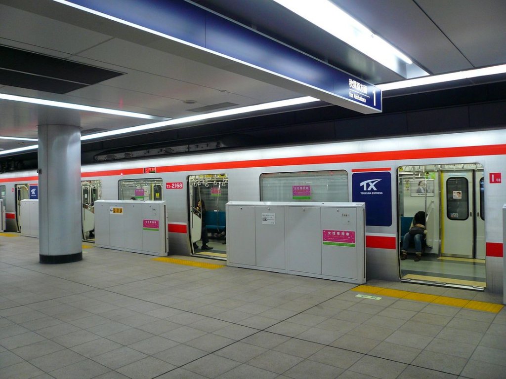 Tsukuba Express Serie 2151: Blick in den Endwagen des Zuges 2168 an der Endstation Tsukuba. Gut erkennbar die fr neuere Bahnhfe im Raum Tokyo angebrachten Schutzwnde an den Bahnsteigkanten, deren Tren sich in Koppelung mit den Wagentren ffnen und schliessen. Die dort angebrachten rosaroten Anzeigen weisen darauf hin, dass in der morgendlichen Stosszeit hier nur Frauen einsteigen drfen. 25.November 2009. 