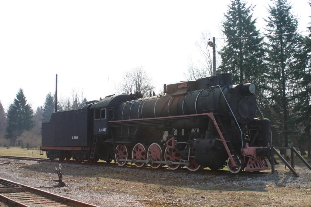 Tri 1.5.2006
In der Einfahrt zum Bahnhof Tri, direkt am Bahnbergang der 
vorbeifhrenden Hauptstrae, hat man diese russische Dampflok
aufgestellt. Es handelt sich um L - 5049. Frher tat sie bei
den estlndischen Eisenbahnen Dienst.
