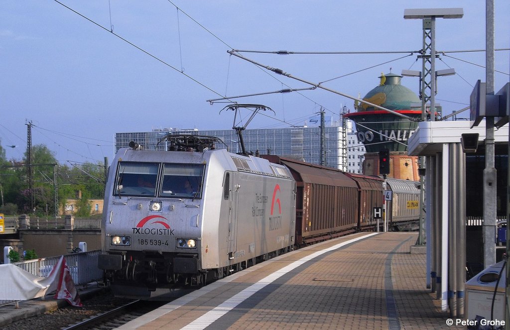 TX Logistic 185 539-4 vor Gterzug (Ladung Papierrollen) Richtung Sden, fotografiert bei der Durchfahrt Halle / Saale Hbf. mit dem markanten Wasserturm im Hintergrund am 02.05.2010