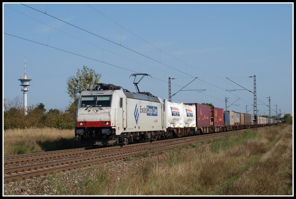 Typisch f�r das Motiv in Wiesental ist der Turm im linken Bildrand. W�hrenddessen f�hrt gerade 185 581 mit einem Ewals-KV Richtung Karlsruhe durch.