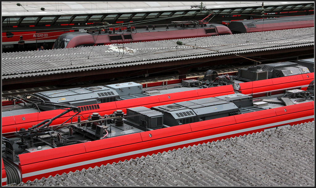 Über das Dach geblickt - 

Im Vergleich zum leuchtenden DB-Rot wirkt die Farbe des Railjets recht stumpf. 

Ulm Hauptbahnhof, 17.06.2012 (M)