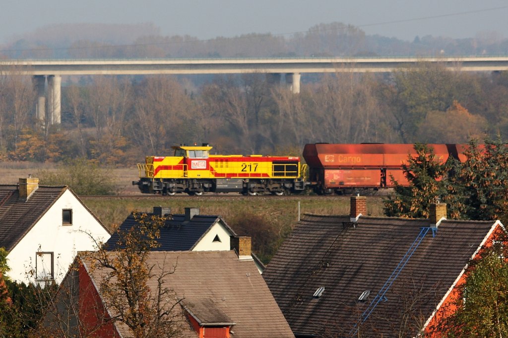 ber die Dcher von Kriechau hinweg zieht MEG 217 ihr Kohlependel von Whlitz in Richtung Grokorbetha und weiter nach Buna, im Hintergrund die Autobahn 38. 31.10.09 (Tele-Ausschnitt)