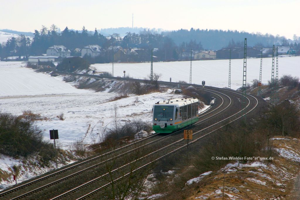 Un hier ein Blick in Richtung der Ortslage Feilitzsch. Die Oberleitungsmasten sind in grosser Zahl bis zum HP Feilitzsch aufgestellt als ein VBG Triebwagen von Feilitzsch herauf kommt. Er hat noch den Arriva-Schriftzug an der Front. Zwischenzeitlich sind die Arbeiten wieder weiter, denn das Bild ist vom 24.02.2011 und es wird auch Sonntag gearbeitet...